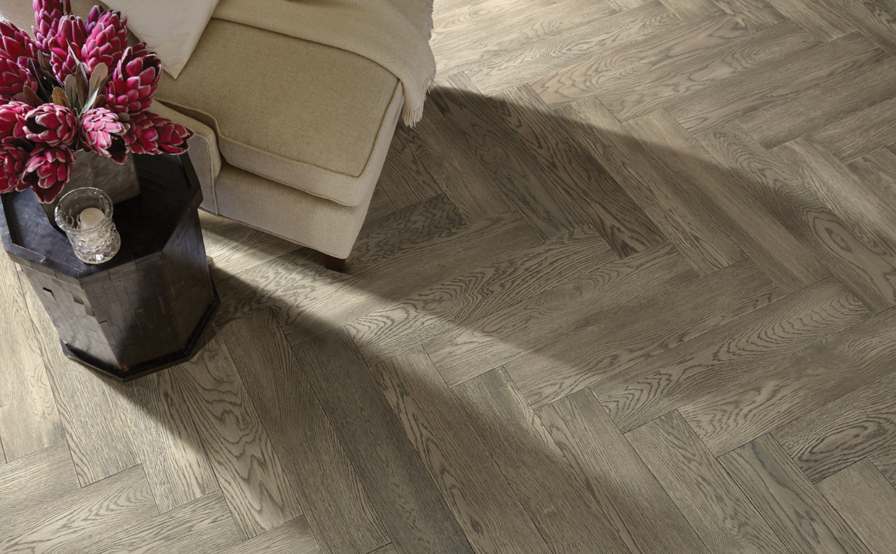 Herringbone hardwood floor and beige chair 